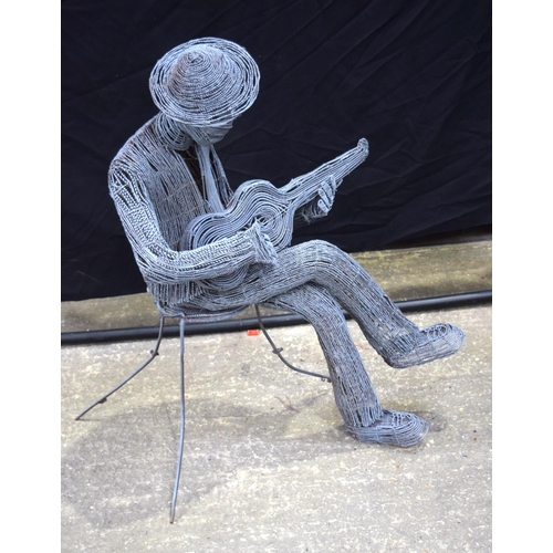 3494 - A twisted wire sculpture of a seated man playing a ukulele 92 cm .