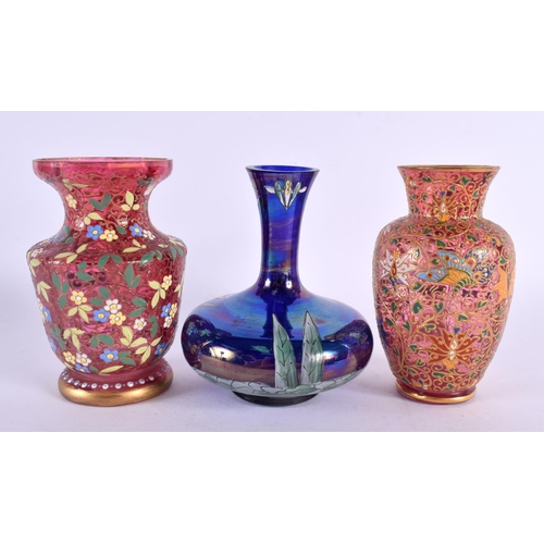 176 - TWO ANTIQUE BOHEMIAN ENAMELLED RUBY GLASS VASES together with another enamelled iridescent vase. Lar... 