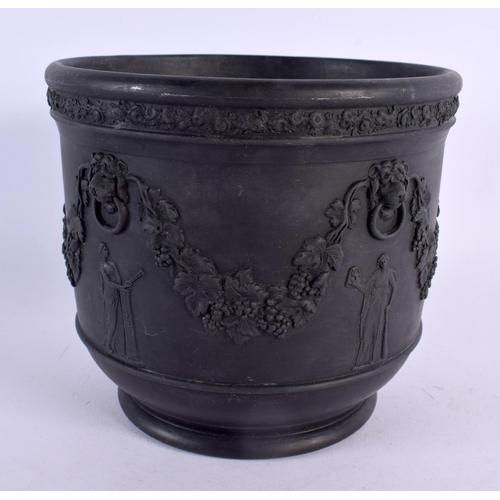 177 - AN ANTIQUE WEDGWOOD BLACK BASALT JARDINIERE decorated with berries and vines. 15 cm x 13 cm.