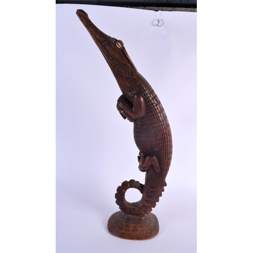 321 - A LARGE SOUTHSEA ISLANDS TRIBAL POLYNESIAN CARVED WOOD CROCODILE modelled as a kayman clutching shel... 