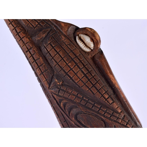 321 - A LARGE SOUTHSEA ISLANDS TRIBAL POLYNESIAN CARVED WOOD CROCODILE modelled as a kayman clutching shel... 