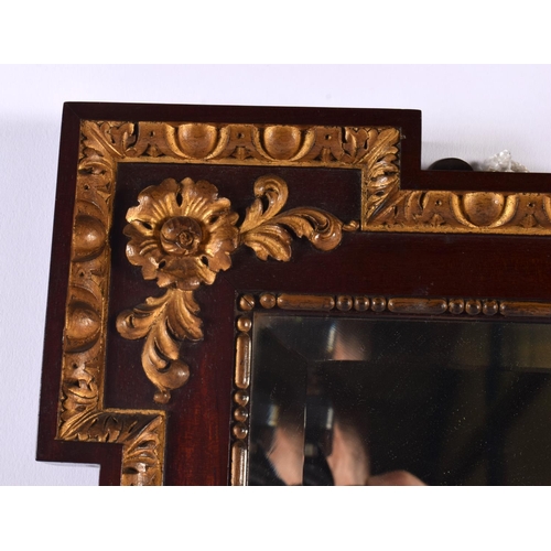 343 - AN ANTIQUE MAHOGANY AND GILTWOOD ACANTHUS CAPPED MIRROR decorated with floral roundels. 52 cm x 42 c... 