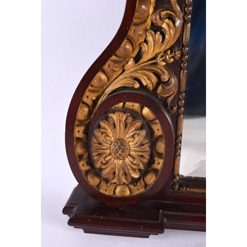 343 - AN ANTIQUE MAHOGANY AND GILTWOOD ACANTHUS CAPPED MIRROR decorated with floral roundels. 52 cm x 42 c... 