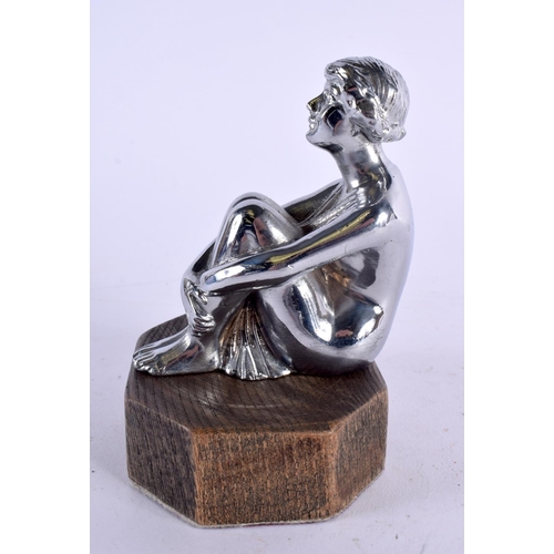 404 - AN ART DECO CHROME CAR MASCOT formed as a seated female clutching her legs. 14 cm x 9 cm.