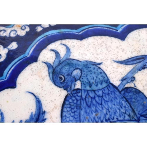 435 - TWO MIDDLE EASTERN IZNIK TILES one painted with birds, the other foliage. 24 cm x 17 cm. (2)