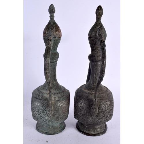 528 - A PAIR OF 19TH CENTURY MIDDLE EASTERN BRONZED COPPER EWERS decorated with foliage and vines. 32 cm x... 