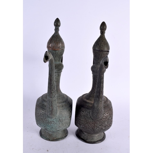 528 - A PAIR OF 19TH CENTURY MIDDLE EASTERN BRONZED COPPER EWERS decorated with foliage and vines. 32 cm x... 