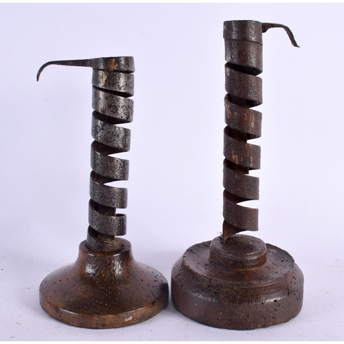 530 - TWO EARLY IRON PIG TAIL TWIST COUNTRY CANDLESTICKS. 20 cm high.