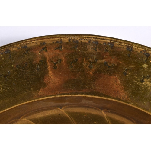 557 - A LARGE 18TH CENTURY EUROPEAN BRASS ALMS DISH decorated with repousse motifs. 48 cm diameter.