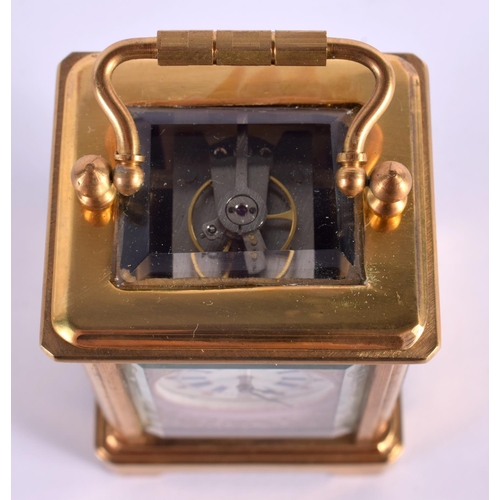 613 - A CONTEMPORARY MINIATURE BRASS PORCELAIN CARRIAGE CLOCK. 7.5 cm high inc handle.