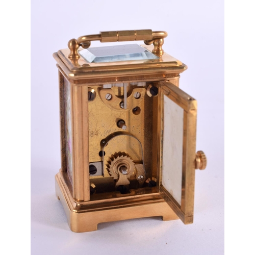 613 - A CONTEMPORARY MINIATURE BRASS PORCELAIN CARRIAGE CLOCK. 7.5 cm high inc handle.