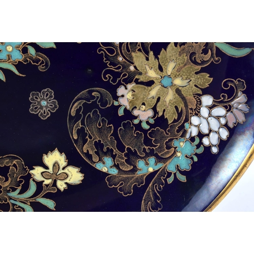 63 - AN ART NOUVEAU FRENCH ENAMELLED BLUE PLATE painted with raised enamel foliage. 28 cm diameter.