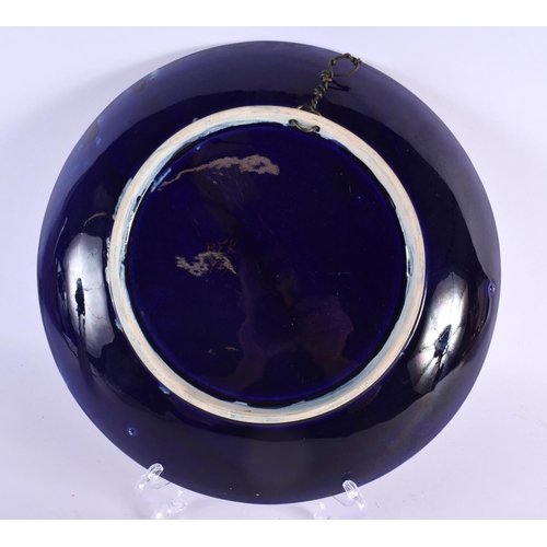 63 - AN ART NOUVEAU FRENCH ENAMELLED BLUE PLATE painted with raised enamel foliage. 28 cm diameter.