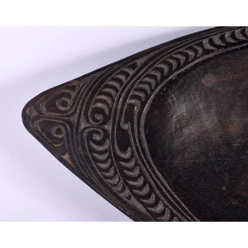 638 - AN UNUSUAL TRIBAL POLYNESIAN MAORI CARVED WOOD DISH decorated with motifs. 25 cm x 10 cm.