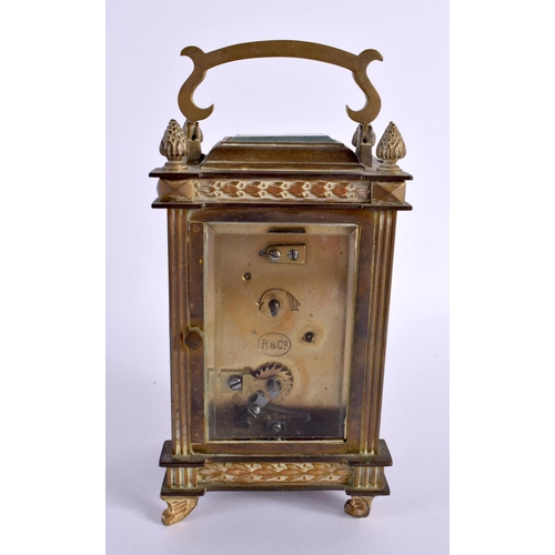 658 - AN EARLY 20TH CENTURY FRENCH BRASS BOUND CARRIAGE CLOCK with foliate enamel dial. 16 cm high inc han... 