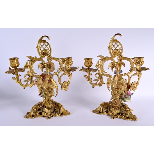 675 - A PAIR OF 19TH CENTURY CONTINENTAL PORCELAIN AND BRONZE CANDLESTICKS formed with figures amongst vin... 