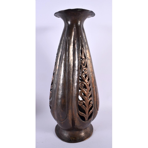 702 - AN ART NOUVEAU EMBOSSED HAMMERED COPPER RETICULATED VASE decorated with foliage. 37 cm x 12 cm.