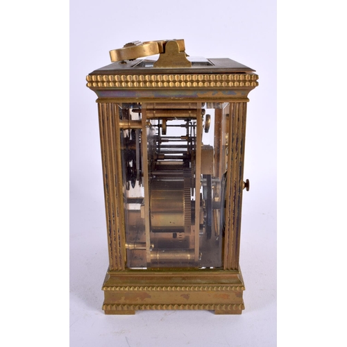 710 - AN ANTIQUE REPEATING BRASS CARRIAGE CLOCK. 18 cm high inc handle.