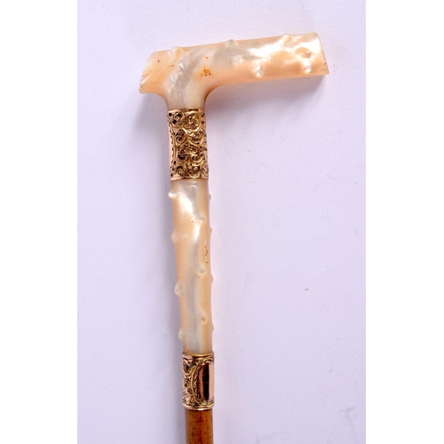 715 - A VICTORIAN YELLOW METAL MOUNTED MOTHER OF PEARL SWAGGER STICK. 74 cm long.