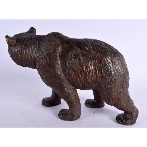 776 - A 19TH CENTURY BAVARIAN BLACK FOREST CARVED WOOD FIGURE OF A BEAR modelled roaming. 24 cm x 15 cm.