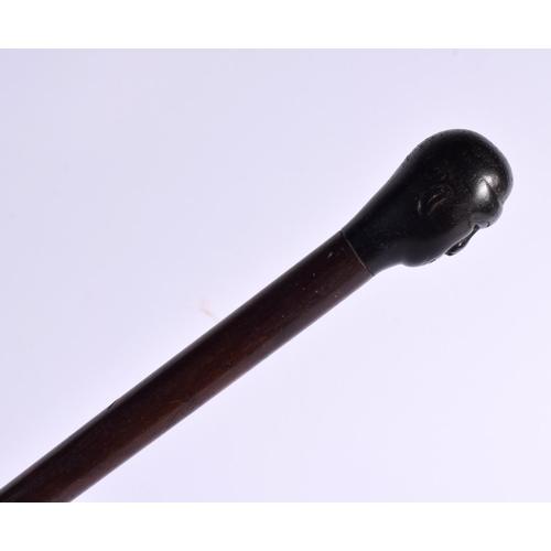 800 - AN 18TH/19TH CENTURY CONTINENTAL CARVED SWAGGER STICK formed as with a blackamoor head. 75 cm long.