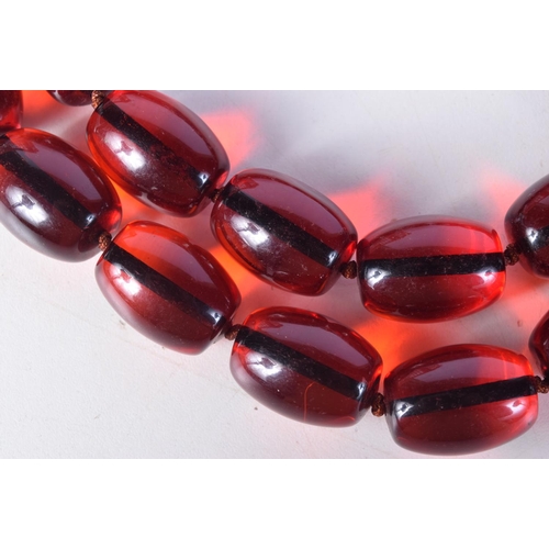 1413 - A STRING OF CHERRY BEADS. 93cm long, largest bead 18.4mm, weight 206g