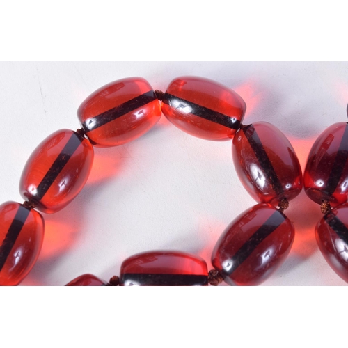 1413 - A STRING OF CHERRY BEADS. 93cm long, largest bead 18.4mm, weight 206g