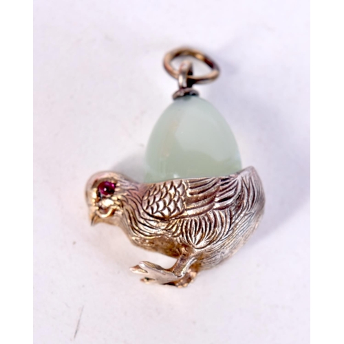 1448 - A SILVER PENDANT IN THE FORM OF A CHICK WITH GEM SET EYES AND A JADE EGG. 3.2cm x 2.1cm x 1.1cm, wei... 