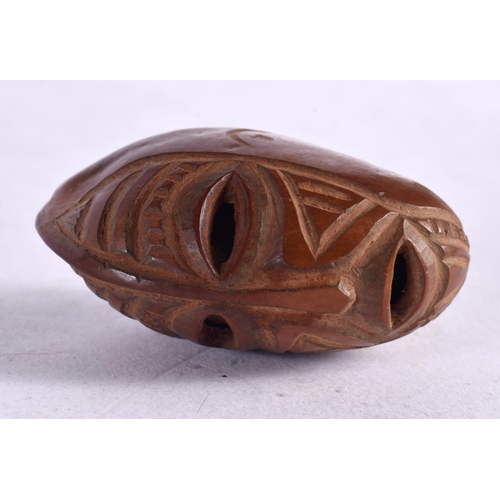 1648 - AN ANTIQUE AFRICAN CARVED TRIBAL NUT. 5 cm x 3 cm.