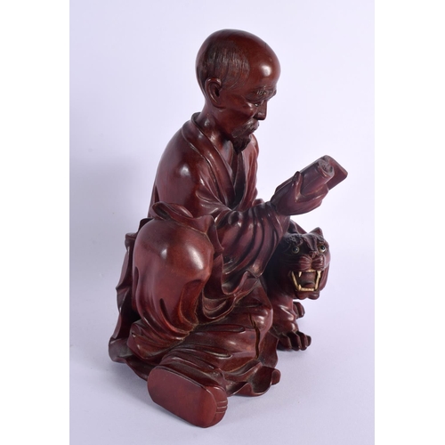 2075 - A LATE 19TH CENTURY CHINESE CARVED HARDWOOD FIGURE OF A MALE Qing, modelled beside a tiger. 22 cm x ... 