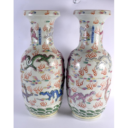 2121 - A LARGE PAIR OF CHINESE TWIN HANDLED FAMILLE ROSE VASES 20th Century, overlaid in relief with dragon... 