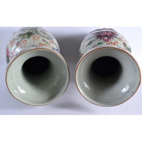 2121 - A LARGE PAIR OF CHINESE TWIN HANDLED FAMILLE ROSE VASES 20th Century, overlaid in relief with dragon... 