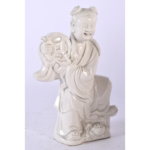 580 - AN 18TH CENTURY CHINESE BLANC DE CHINE PORCELAIN FIGURE OF A YOUNG GIRL Qing, modelled holding aloft... 