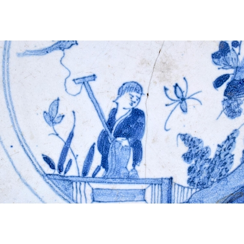 115 - A LARGE 18TH CENTURY DELFT BLUE AND WHITE TIN GLAZED DISH painted with a Chinese figure in a landsca... 