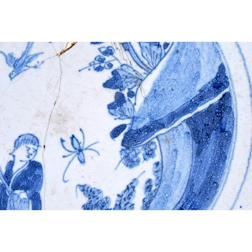 115 - A LARGE 18TH CENTURY DELFT BLUE AND WHITE TIN GLAZED DISH painted with a Chinese figure in a landsca... 