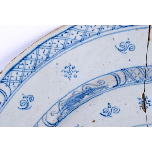 115 - A LARGE 18TH CENTURY DELFT BLUE AND WHITE TIN GLAZED DISH painted with a Chinese figure in a landsca... 