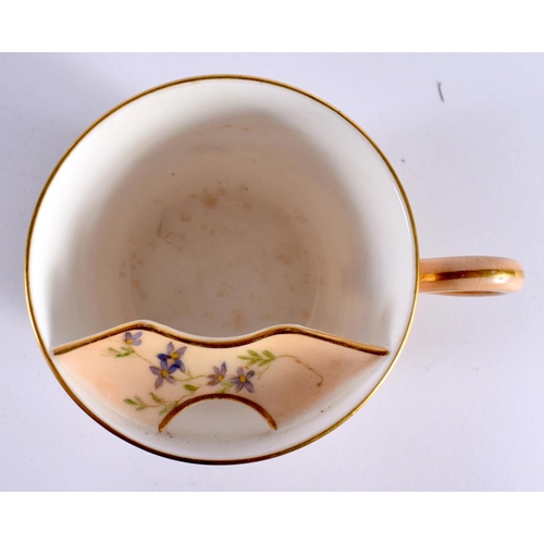 127 - A ROYAL WORCESTER BLUSH IVORY MOUSTACHE CUP AND SAUCER painted with flowers. 14cm diameter. (2)