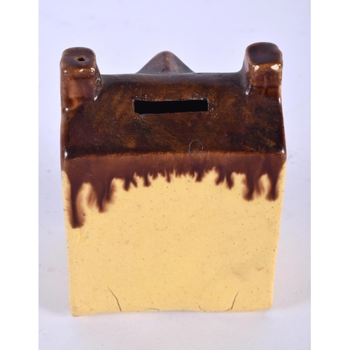 13 - AN ANTIQUE TREACLE GLAZED POTTERY MONEY BOX formed as a house. 10 cm x 6 cm.