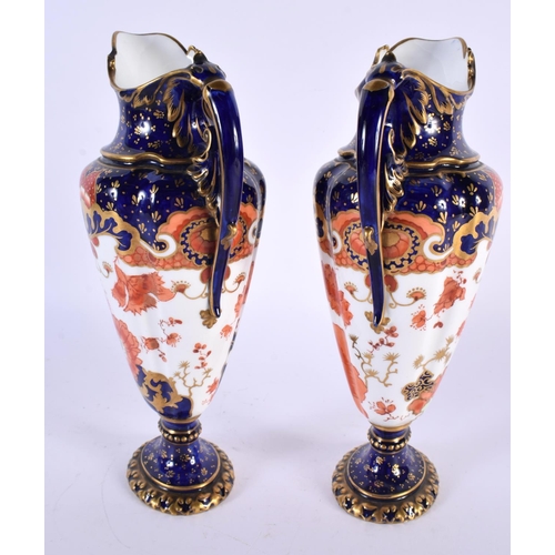 137 - A PAIR OF ROYAL CROWN DERBY PORCELAIN EWERS painted with foliage. 23 cm high.