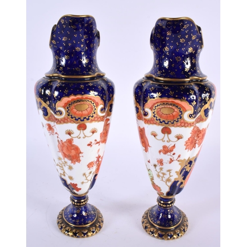 137 - A PAIR OF ROYAL CROWN DERBY PORCELAIN EWERS painted with foliage. 23 cm high.