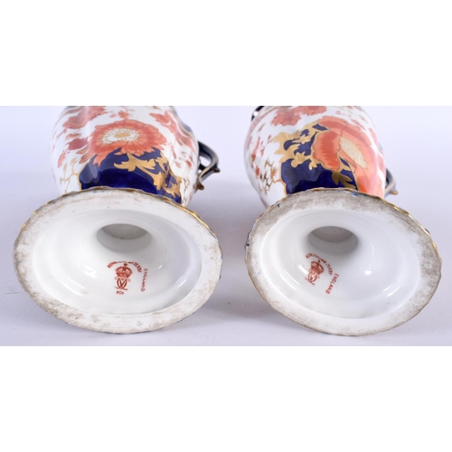 137 - A PAIR OF ROYAL CROWN DERBY PORCELAIN EWERS painted with foliage. 23 cm high.