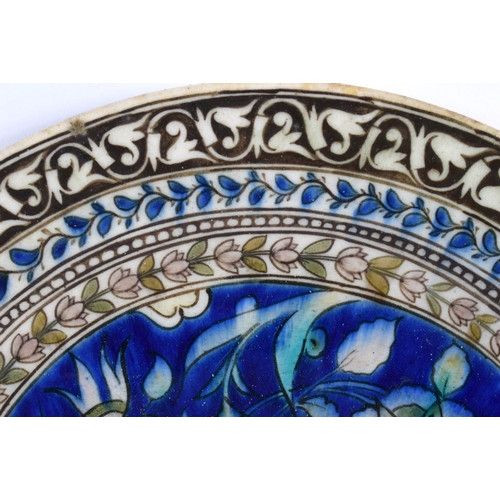 144 - AN 18TH/19TH CENTURY MIDDLE EASTERN IZNIK POTTERY DISH painted with flowers. 27 cm diameter.