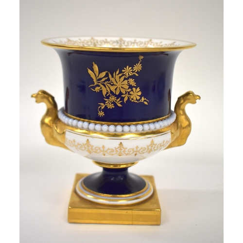 189 - Royal Worcester urn shaped vase painted with flowers on a cobalt blue groud, the vase having griffin... 