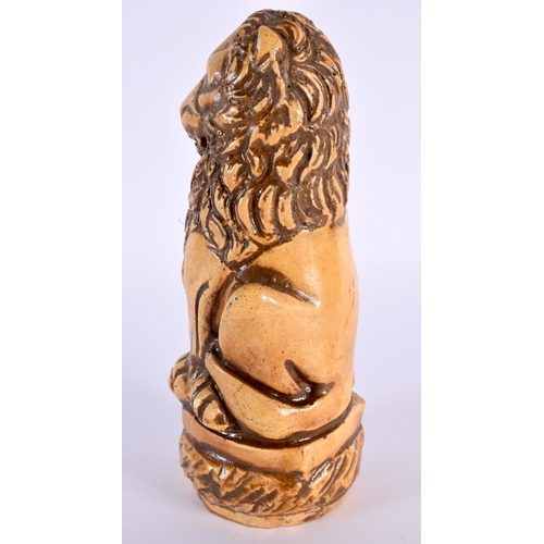 27 - AN UNUSUAL 18TH CENTURY FRENCH SALT GLAZED POTTERY FIGURE OF A LION modelled holding a fleur de lys ... 