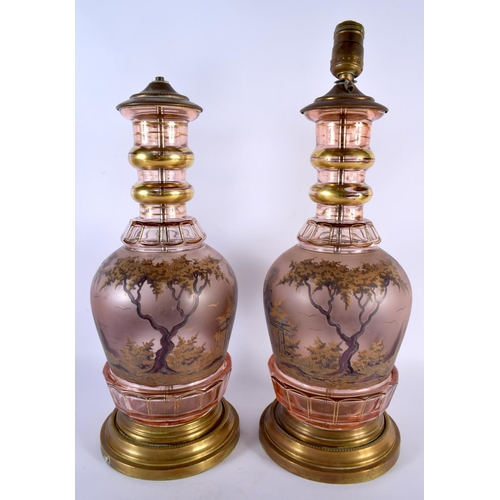 30 - A LARGE PAIR OF 19TH CENTURY BOHEMIAN GLASS LAMPS painted with figures in landscapes. 46 cm high.