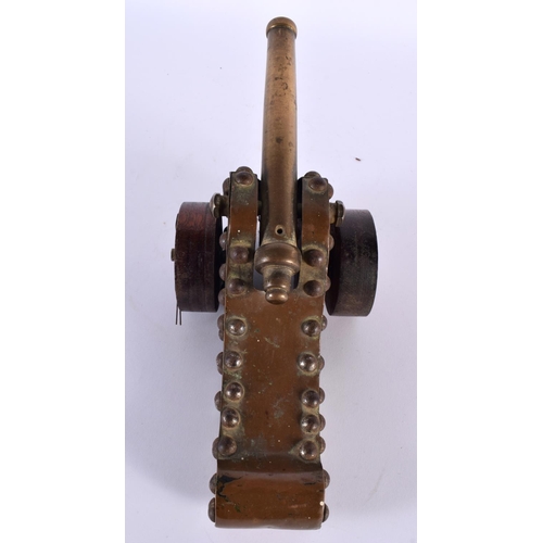 357 - A 19TH CENTURY COUNTRY HOUSE BRONZE AND CARVED WOOD DESK CANNON upon revolving wheels. 27 cm wide.