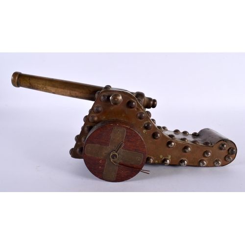 357 - A 19TH CENTURY COUNTRY HOUSE BRONZE AND CARVED WOOD DESK CANNON upon revolving wheels. 27 cm wide.