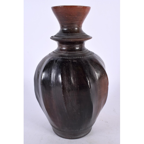 411 - AN ANTIQUE MIDDLE EASTERN WRYTHEN MOULDED POTTERY VASE with faint incised decoration. 23 cm high.