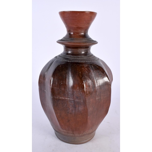 411 - AN ANTIQUE MIDDLE EASTERN WRYTHEN MOULDED POTTERY VASE with faint incised decoration. 23 cm high.