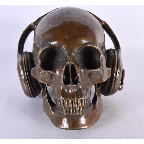 427 - A LARGE CONTEMPORARY BRONZE SKULL AND HEADPHONES MODEL. 18cm x 16 cm.